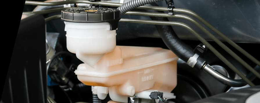 Maître-cylindre de frein avec réservoir de liquide translucide et conduites montrant les composants du système hydraulique