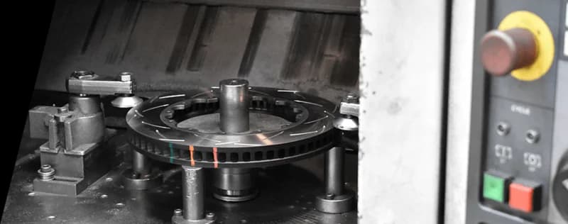 Disque de frein DBA avec indicateurs de température colorés en cours de fabrication sur machine CNC de précision avec panneau de contrôle visible