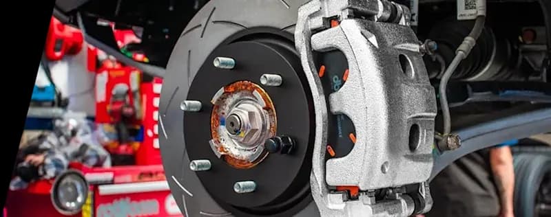 Gros plan sur système de freinage performant montrant un disque rainuré DBA installé sur véhicule avec étrier argenté et moyeu visible