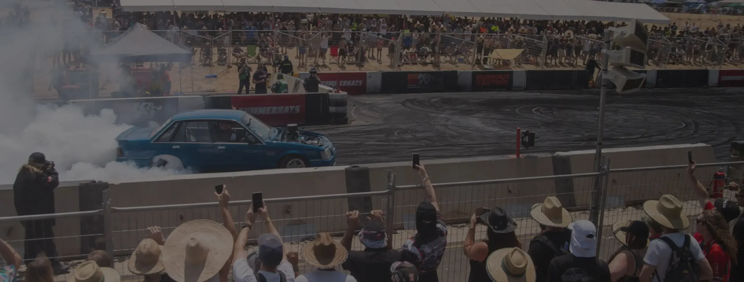 Performance des freins DBA démontrée en course automobile avec spectateurs regardant voiture effectuant un burnout sur circuit