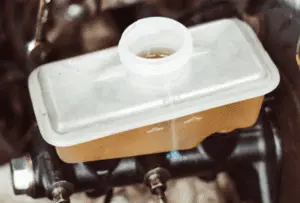 Réservoir de liquide de frein correctement rempli montrant le niveau approprié au repère maximum suite à la purge complète du système Réservoir de liquide de frein en plastique translucide montrant le niveau de liquide à la ligne de remplissage maximum après la purge complète